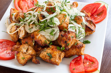 Fried skewers on the grill in a white dish