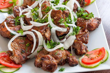 Fried skewers on the grill in a white dish