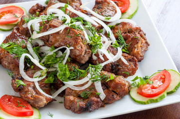 Fried skewers on the grill in a white dish