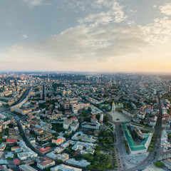 Fototapeta na wymiar Panorama of the city of Kiev at sunset. A modern metropolis in the center of Europe against the backdrop of sunset sky from a bird's eye view. Aerial view. Panorama of the Tourist Center of Kiev.