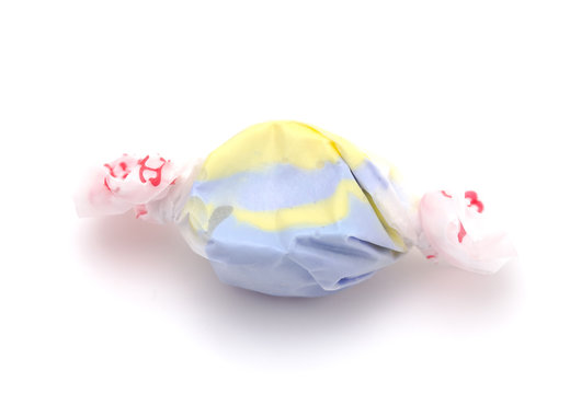 Single Piece of Yellow and Purple Salt Water Taffy on a White Background