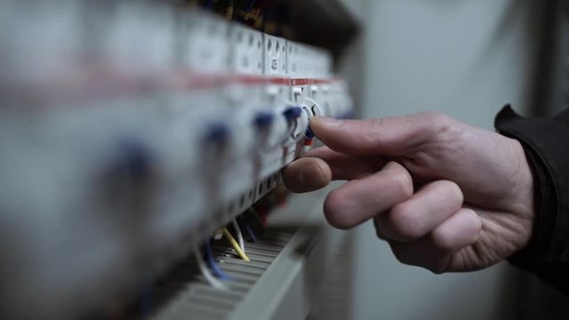 The engineer turns off the circuit breakers in the electrical panel