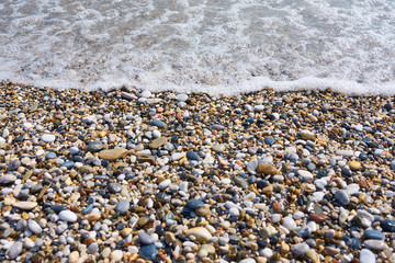 Soft wave of sea on pebble beach. Background. 