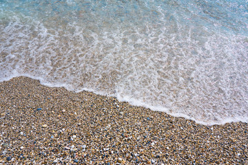Soft wave of sea on pebble beach. Background. 