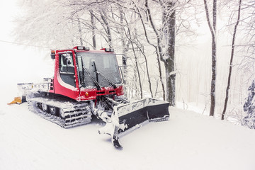 A parked snow plow covered with snow in the mountains in winter, Vosges, France