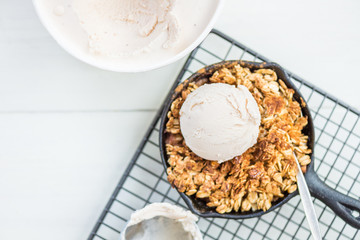 Homemade cooked rhubarb and apple crumble with oatmeal and vanilla ice cream