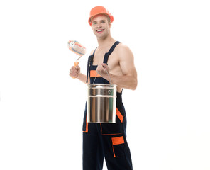 Painter holds paint roller&paint bucket. Smiling painter, decorator in protective helmet&uniform...