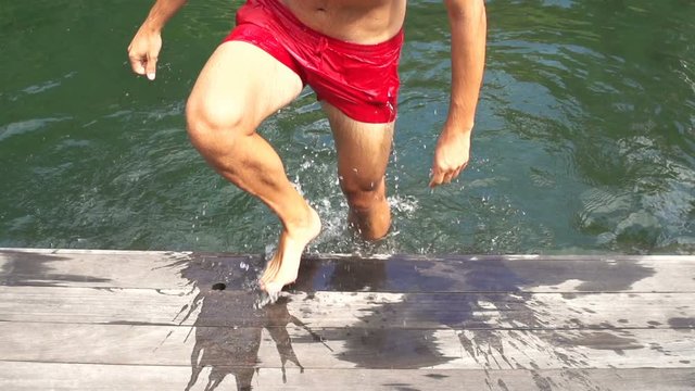 Young man walking out of swimming pool, super slow motion 240fps
