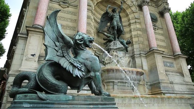 The Fontaine Saint-Michel is one of the most monumental fountains in the Place Saint-Michel. In front of the fountain, two water-spouting dragons. Perspective view. Paris, France in europe.
