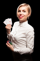 Beautiful blond girl smiling and showing a poker cards and gambling chips
