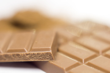 Chocolate bar pieces and cocoa powder on white background. Brown chocolate powder.