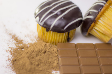 Small chocolate cake and cocoa powder and chocolate bar