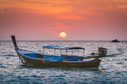Longtail boats at Sunset Beach, Ko Lipe, Satun Province, Thailand. Traditional long tail boat and rising sun.