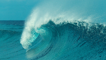 CLOSE UP: Beautiful emerald colored tube wave rushes towards the tropical coast.