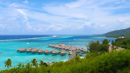 Beautiful overwater villas in stunning lagoon overlooking tropical sunny island.