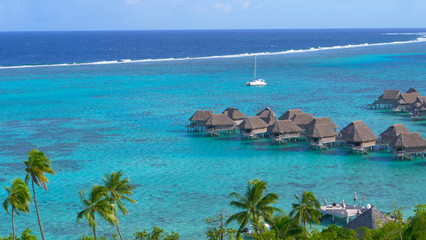 Picturesque overwater villas look towards the endless turquoise colored ocean.