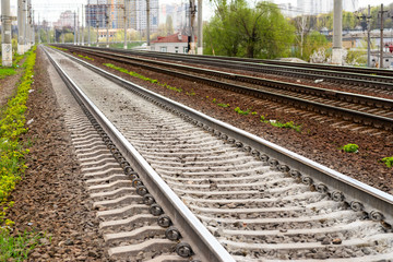 Railway rails with gravel leaving in perspective on the entrance to the city