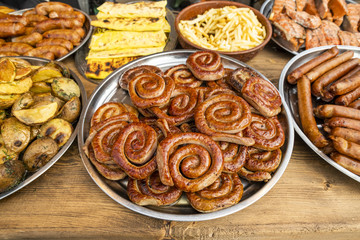 twisted sausages roasted on an open fire on a metal plate on a table