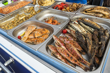 a table with shrimps and mussels and fried fish on the market counter