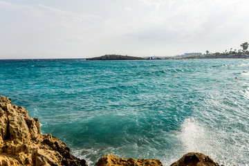 Beautiful summer Mediterranean landscape, lit by the afternoon sun. Pale blue sky and turquoise blue salty waters flooding the shore. Copy space.
