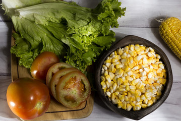  corn in a clay bowl accompanied by frees ensalda