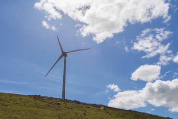 Fototapeta na wymiar A wind turbine against a blue sky
