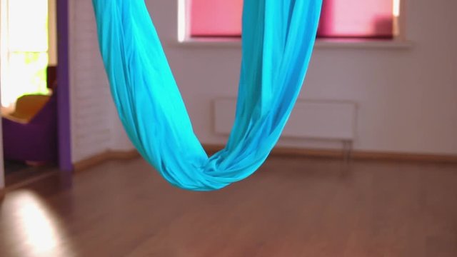 close up of a blue nylon yoga hammock empty studio without visitors with bokeh effect.