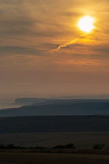 Looking out over the countryside and coastline in Sussex, at sunset