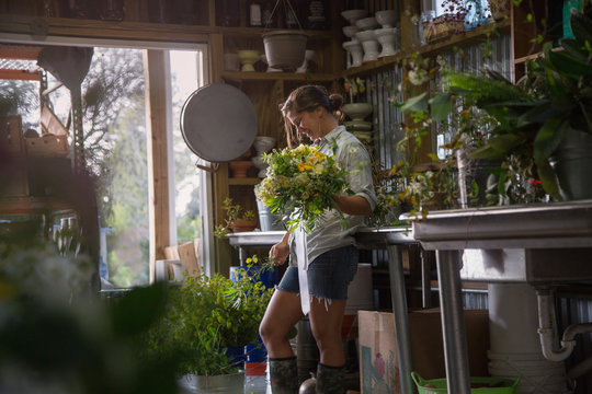 A flower farmer designs and displays a bouquet from flowers she has grown