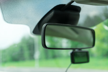 Car rear view mirror. Photograph of the inside of the car.