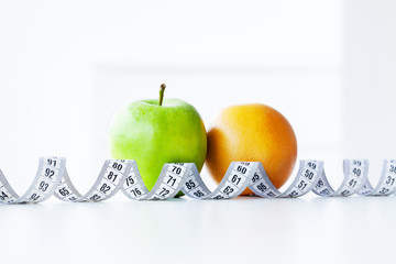 Diet. Fitness and healthy food diet concept. Balanced diet with vegetables. Fresh green vegetables, measuring tape on white background. Closeup