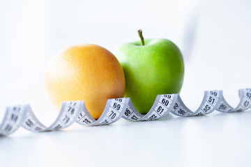 Diet. Fitness and healthy food diet concept. Balanced diet with vegetables. Fresh green vegetables, measuring tape on white background. Closeup