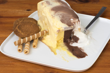 Helado de tres sabores con barquillos y galletas junto al helado