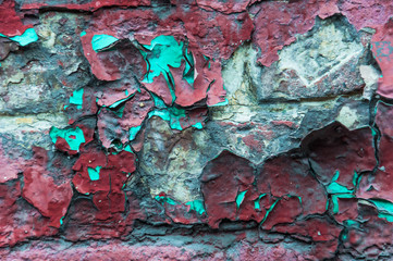 A fragment of an old brick wall painted many times. Peeling paint. Texture. Background