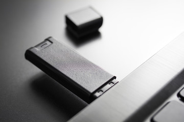 Close-Up Of A Black USB Memory Stick Plugged Into The USB Port Of A Black Notebook, Side View