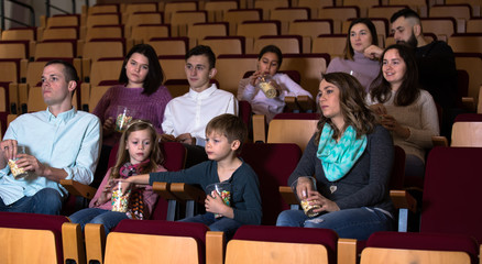 Emotional audience eating popcorn and watching a movie