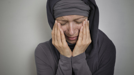 A sad Muslim woman in a hijab cries. Close-up of a weeping Arab girl. 
