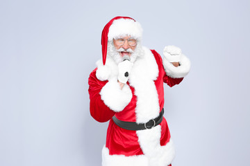 Santa Claus singing into microphone on color background. Christmas music