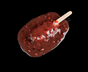 red bean popsicle melting on a black background