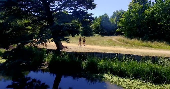 People walk and camera ascends, Wanstead Park in London, Drone footage.