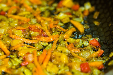 cooking a roast for soup of onions, carrots, paprika, tomatoes, herbs and spices in sunflower oil in a frying pan