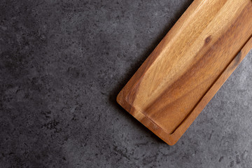 Wooden cutting board on black table background