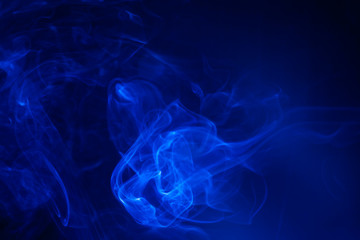 Blue smoke on black background.