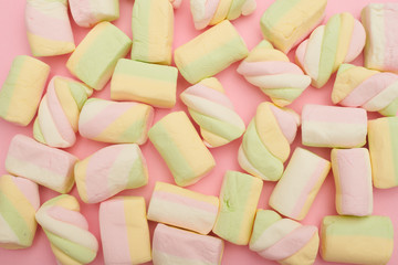 Colorful marshmallows placing on pink flatlay