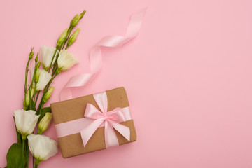 Handmade present box with eustoma flowers on pink flatlay