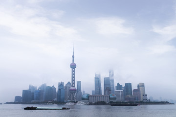 Obraz premium Shanghai Financial Center and modern skyscraper city in misty sunrise behind pollution haze, view from the bund in Shanghai, China. vintage picture style