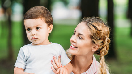 close-up portrait of happy mother with son at park
