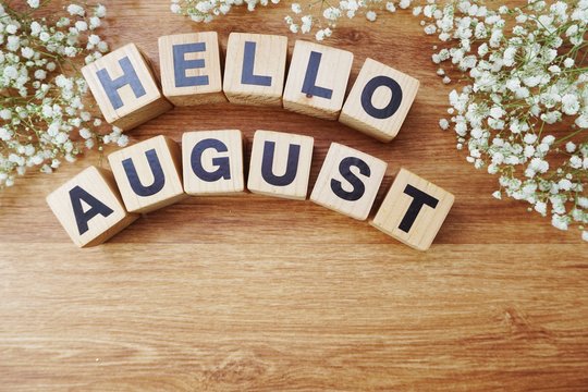 august alphabet letters on wooden background