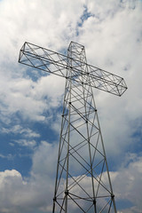 big cross with white clouds on the sky