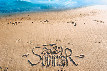 The inscription summer 2018 is written on the sand. The drawing is made by hand. Postcard. Beach holidays. Memories of summer.